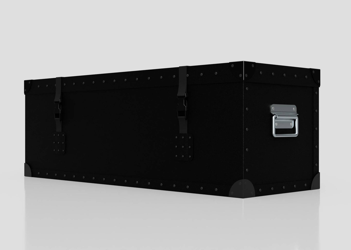The Standard Long Storage Box - Small is a black metal trunk featuring rivets, corner protectors, front latches, and a zinc drop handle on the side, displayed against a plain light background.