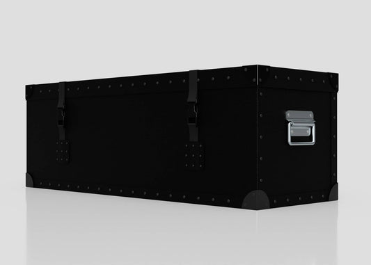 The Standard Long Storage Box - Small is a black metal trunk featuring rivets, corner protectors, front latches, and a zinc drop handle on the side, displayed against a plain light background.