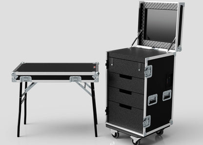 The TM TV Drawer Case, in black with drawers, wheels, and a fold-out monitor, stands beside a portable trestle table against a plain background. It features convenient side attaching and versatile external dimensions for transport.