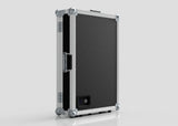 The Vanity Dressing Room Makeup Mirror Case is a black and silver hard-sided case with metal edges, corner protectors, a side handle, and a small rectangular power port on one side.