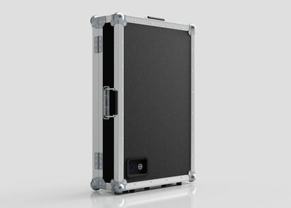 The Vanity Dressing Room Makeup Mirror Case is a black and silver hard-sided case with metal edges, corner protectors, a side handle, and a small rectangular power port on one side.