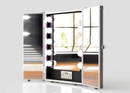 The Vanity Dressing Room Makeup Mirror Case, featuring built-in LED lights and a power outlet, stands open on a wooden surface in a bright room, creating an ideal portable dressing room experience.