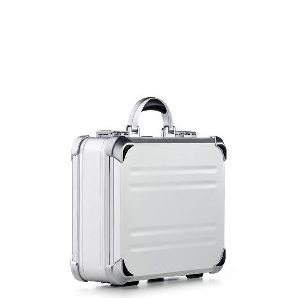 The VDK 97100, a silver aluminium case with rounded corners, a handle, and custom CNC foam fittings, stands upright against a plain white background.