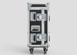 A Yamaha DM7 Compact Case in black and silver, featuring four metal latches, reinforced corners, and four caster wheels, stands upright against a plain gray background.